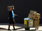 FILE - An Amazon worker delivers packages in Los Angeles on Oct. 1, 2020. July sales events have become a seasonal revenue driver for the retail industry since Amazon launched its first Prime Day back in 2015.