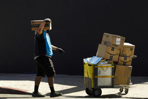 FILE - An Amazon worker delivers packages in Los Angeles on Oct. 1, 2020. July sales events have become a seasonal revenue driver for the retail industry since Amazon launched its first Prime Day back in 2015.
