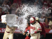 Los Angeles Angels' Willie Calhoun, is hit with water by Anthony Rendon as he scores after hitting a walk-off two-run home run during the 10th inning of a baseball game against the Seattle Mariners Friday, July 12, 2024, in Anaheim, Calif. (AP Photo/Mark J.