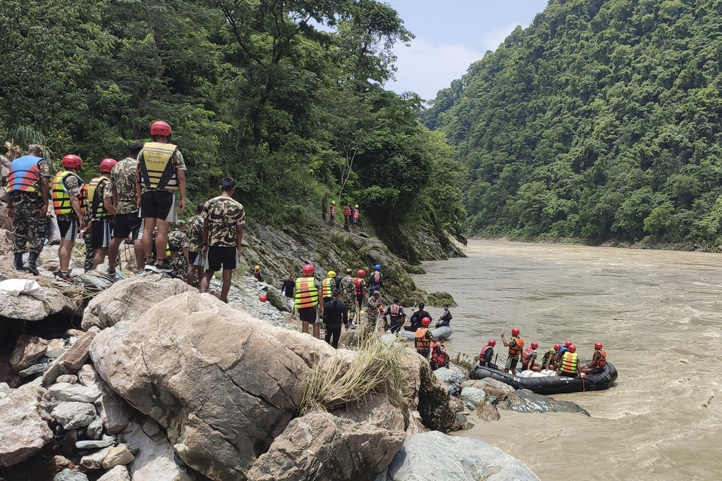 Nepal army personnel cary out a search operation looking for the survivors after two buses were swept by a landslide off the highway and into a swollen river near Simaltal, about 120 kilometers (75 miles) west of the capital Kathmandu, Nepal, Saturday, July 13, 2024.