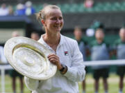 Barbora Krejcikova of the Czech Republic holds her trophy after defeating Jasmine Paolini of Italy in the women's singles final at the Wimbledon tennis championships in London, Saturday, July 13, 2024.