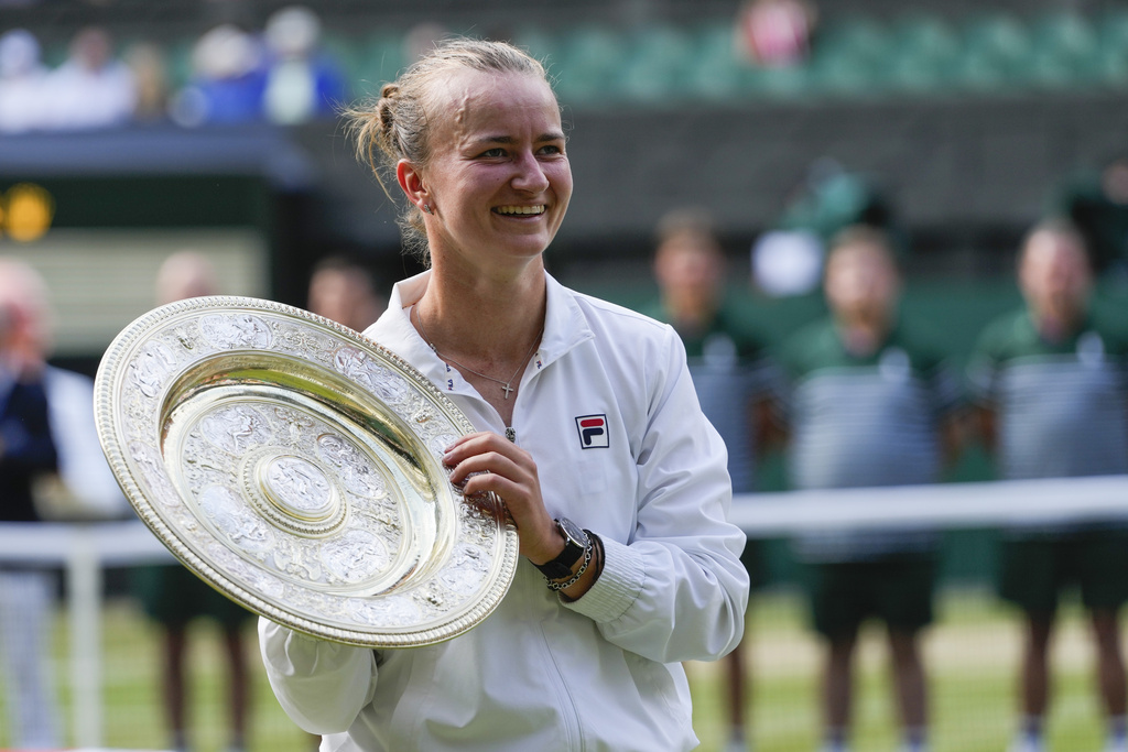 Barbora Krejcikova of the Czech Republic holds her trophy after defeating Jasmine Paolini of Italy in the women's singles final at the Wimbledon tennis championships in London, Saturday, July 13, 2024.