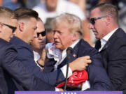 Republican presidential candidate former President Donald Trump is helped off the stage at a campaign event in Butler, Pa., on Saturday, July 13, 2024. (AP Photo/Gene J.