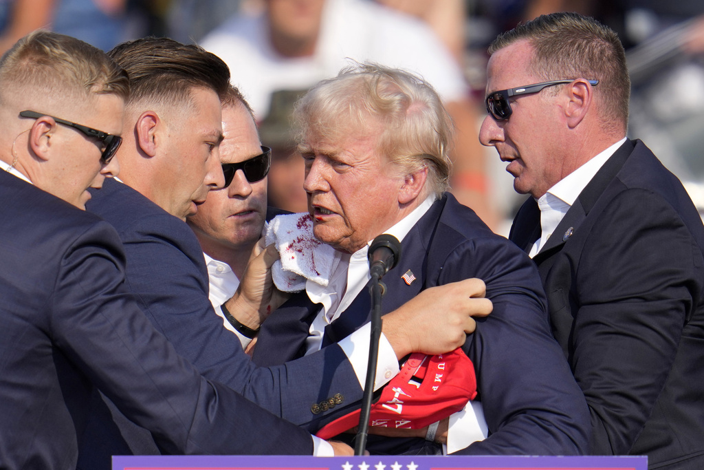 Republican presidential candidate former President Donald Trump is helped off the stage at a campaign event in Butler, Pa., on Saturday, July 13, 2024. (AP Photo/Gene J.