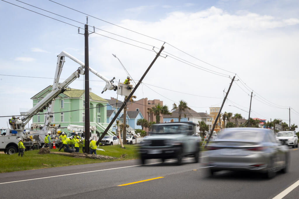 Linemen place a new fiberglass utility pole to replace older, leaning wooden poles along FM 3005 on Galveston Island on Saturday, July 13, 2024.