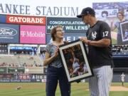 Yankees' Aaron Boone presents an autographed picture to Kathy Willens on June 28, 2021, in New York, of her picture of New York Yankees pitcher David Cone after Cone threw a perfect game.