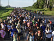 Migrants walk along the highway through Suchiate, Chiapas state in southern Mexico, Sunday, July 21, 2024, during their journey north toward the U.S. border. (AP Photo/Edgar H.