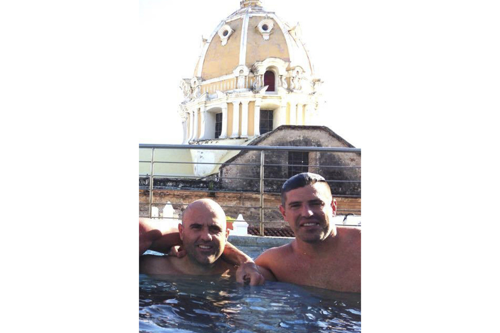 This October 2014 photo obtained by The Associated Press shows then-U.S. Drug Enforcement Administration Agents Jose Irizarry and George Zoumberos in a rooftop pool at a luxury hotel in Cartagena, Colombia, during a DEA assignment for "Operation White Wash." Irizarry long considered Zoumberos a brother but in his interviews with investigators accused his former partner of a list of crimes.