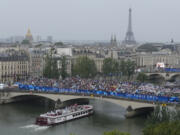 Athletes travel by boat along the Seine river during the opening ceremony of the 2024 Summer Olympics, in Paris, France, Friday, July 26, 2024.