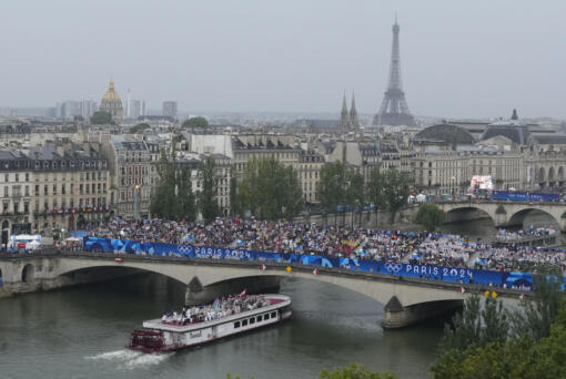 Athletes travel by boat along the Seine river during the opening ceremony of the 2024 Summer Olympics, in Paris, France, Friday, July 26, 2024.