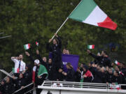 Gianmarco Tamberi waves an Italian flag as the Italian team parades along the Seine river in Paris, France, during the opening ceremony of the 2024 Summer Olympics, Friday, July 26, 2024 (AP Photo/Luca Bruno)