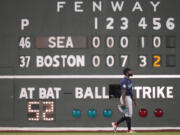 Seattle Mariners left fielder Randy Arozarena walks past the Green Monster scoreboard during the fifth inning of a baseball game against the Boston Red Sox, Monday, July 29, 2024, in Boston.