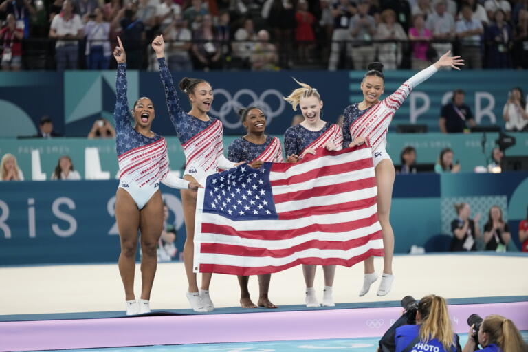 Team USA gymnasts Jordan Chiles, Hezly Rivera, Simone Biles, Jade Carey and Suni Lee celebrate after being announced as the gold medalists of the women's artistic gymnastics team finals round at Bercy Arena at the 2024 Summer Olympics, Tuesday, July 30, 2024, in Paris, France.