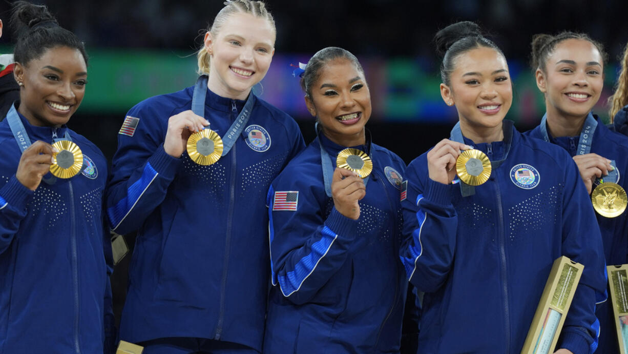 From left to right, Simone Biles, Oregon State's Jade Carey, Prairie High School grad Jordan Chiles, Suni Lee and Hezly Rivera celebrates after winning the gold medal during the women's artistic gymnastics team finals round at Bercy Arena at the 2024 Summer Olympics, Tuesday, July 30, 2024, in Paris, France.