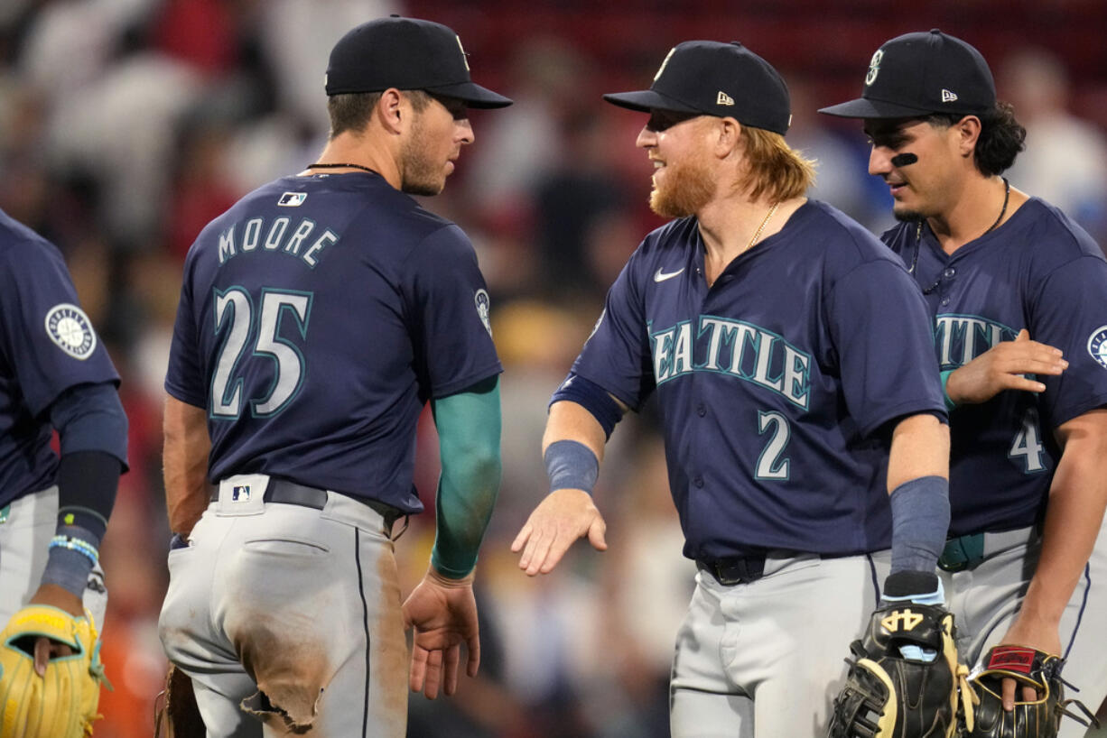 Seattle Mariners Justin Turner (2) celebrates with Dylan Moore (25) after defeating the Boston Red Sox 10-6 following a baseball game, Tuesday, July 30, 2024, in Boston.