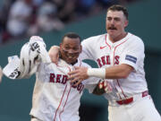 Boston Red Sox's Rafael Devers, left, celebrates after his game-winning RBI double, which drove in Tyler O'Neill, during the 10th inning of a baseball game against the Seattle Mariners, Wednesday, July 31, 2024, in Boston. At right is Boston Red Sox shortstop Romy Gonzalez.