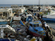 Fishermen push a boat damaged by Hurricane Beryl at the Bridgetown fisheries, Barbados, Tuesday, July 2, 2024.