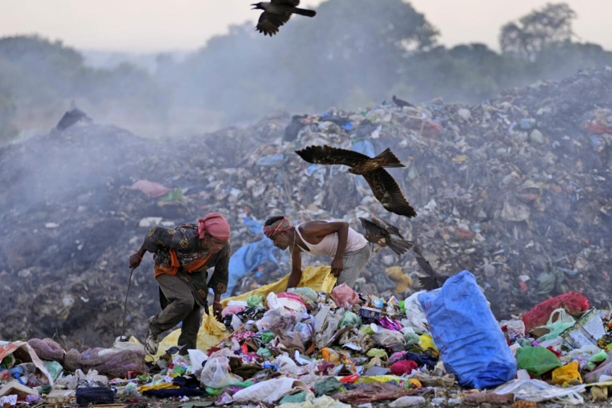 Waste pickers Salmaa and Usmaan Shekh, right, search for recyclable materials June 19 during a heat wave at a garbage dump on the outskirts of Jammu, India.