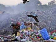 Waste pickers Salmaa and Usmaan Shekh, right, search for recyclable materials June 19 during a heat wave at a garbage dump on the outskirts of Jammu, India.