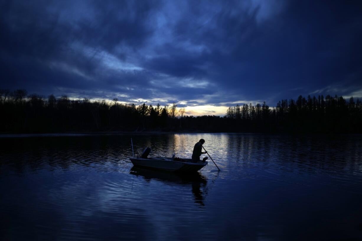 Gabe Bisonette uses a pole to move his boat toward shore while getting ready for a night of spearfishing on the Chippewa Flowage Monday, April 15, 2024, near Hayward, Wis.