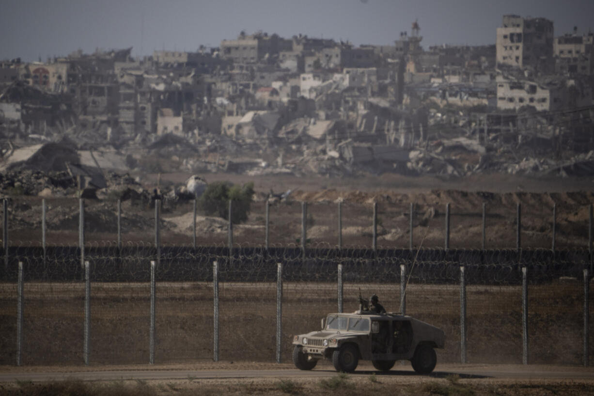 Israeli soldiers move near the Israeli-Gaza border, as seen from southern Israel, Monday, July 8, 2024. Israeli forces advanced deeper into the Gaza Strip&rsquo;s largest city in pursuit of militants who had regrouped there, sending thousands of Palestinians fleeing on Monday from an area ravaged in the early weeks of the nine-month-long war.