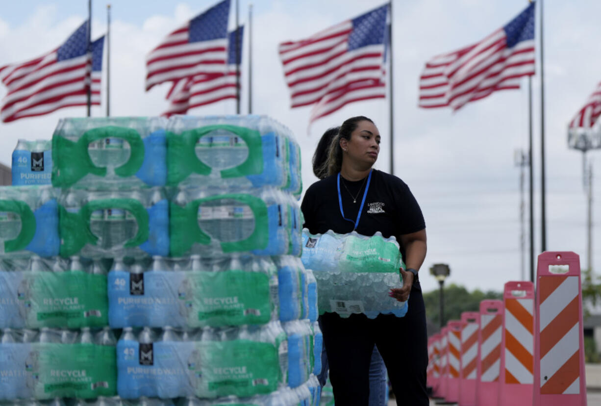 Staff at Lakewood Church hand out water and operate a cooling station in Houston, Tuesday, July 9, 2024. The effects of Hurricane Beryl left most in the area without power.