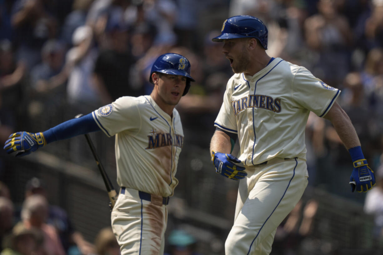 Seattle Mariners&#039; Luke Raley, right, celebrates with Dylan Moore after hitting a three-run home run during the sixth inning of a baseball game against the Houston Astros, Sunday, July 21, 2024, in Seattle.