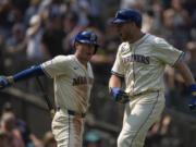 Seattle Mariners&#039; Luke Raley, right, celebrates with Dylan Moore after hitting a three-run home run during the sixth inning of a baseball game against the Houston Astros, Sunday, July 21, 2024, in Seattle.