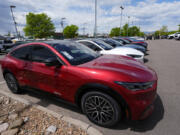 FILE - A line of unsold 2024 Mustang Mach-E electric utility vehicles sit at a Ford dealership May 19, 2024, in Denver. On Tuesday, July 2, 2024, automakers will report second-quarter U.S. sales and they&#039;re expected to be flat compared with a year ago.