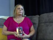 Lori Ellinger holds a candle with a photo of her son, Trea Ellinger, Monday, July 1, 2024, in her home in Glen Burnie, Md.