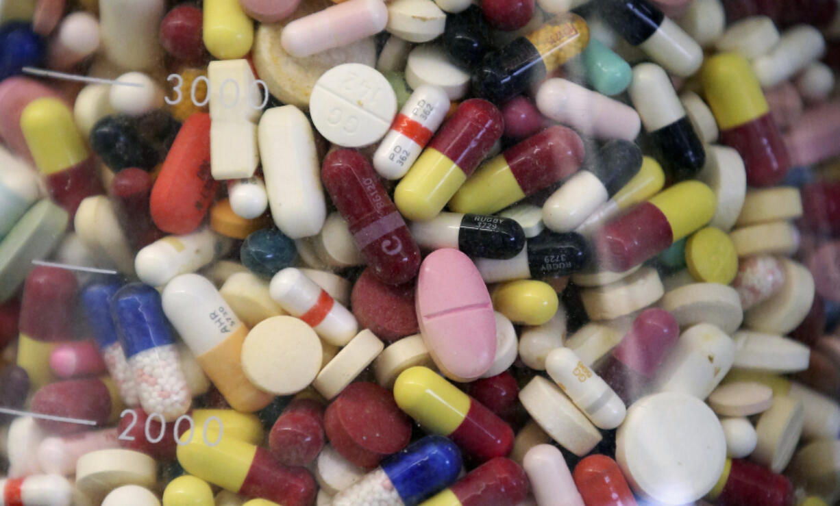 FILE - Prescription drugs are seen in a glass flask at a state laboratory in Taylorsville, Utah, on July 6, 2017.