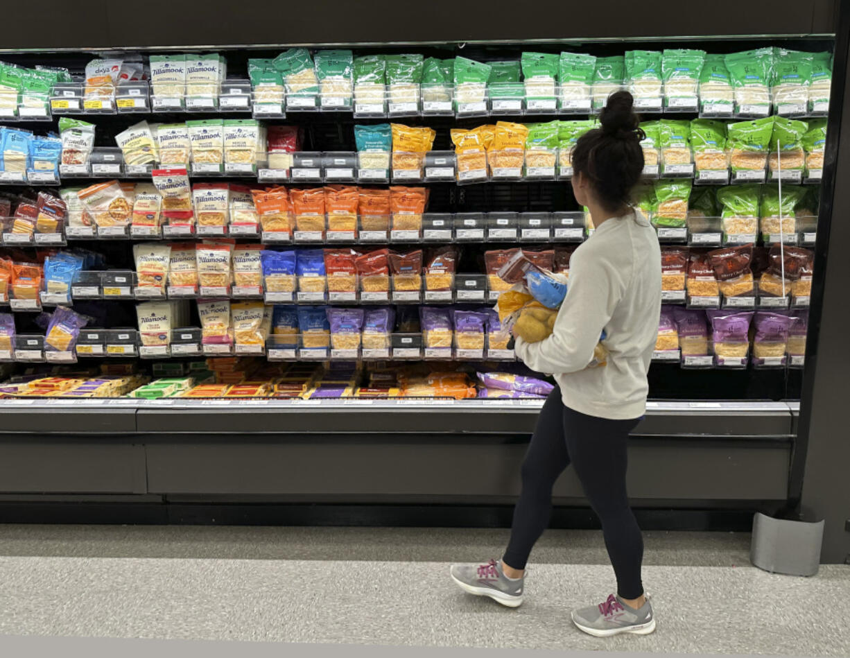 A shopper peruses cheese offerings at a Target store in Sheridan, Colo. Inflation is easing slightly, but grocery prices are still high.