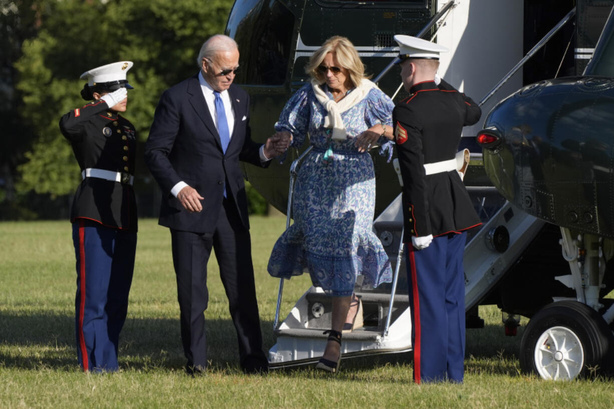 President Joe Biden holds the hand of first lady Jill Biden as they arrive on Marine One at Fort Lesley J. McNair, Monday, in Washington, on return from Camp David.