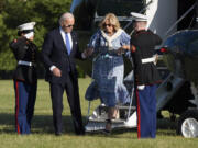 President Joe Biden holds the hand of first lady Jill Biden as they arrive on Marine One at Fort Lesley J. McNair, Monday, in Washington, on return from Camp David.