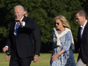 President Joe Biden, from left, waves as he arrives at Fort Lesley J. McNair accompanied by first lady Jill Biden and son Hunter Biden, Monday, July 1, 2024, in Washington, on return from Camp David.