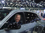 FILE - President Joe Biden drives a Cadillac Lyriq through the showroom during a tour at the Detroit Auto Show, Sept. 14, 2022, in Detroit. The Biden administration is awarding nearly $2 billion in grants to help restart or expand electric vehicle manufacturing and assembly sites in eight states, including the presidential battlegrounds of Michigan, Pennsylvania and Georgia. Grants totaling $1.7 billion will be issued by the Energy Department to create or retain thousands of union jobs and support auto-based communities that have long driven the U.S. economy, the White House said Thursday, July 11, 2024.