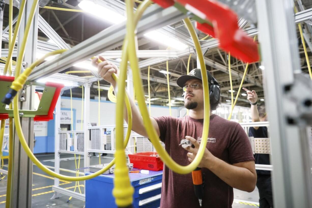 Dmitriy Rudenko grabs an air hose during a media tour during a brief media tour at the Boeing facility in Renton, Wash., Tuesday, June 25, 2024.