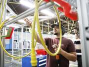 Dmitriy Rudenko grabs an air hose during a media tour during a brief media tour at the Boeing facility in Renton, Wash., Tuesday, June 25, 2024.