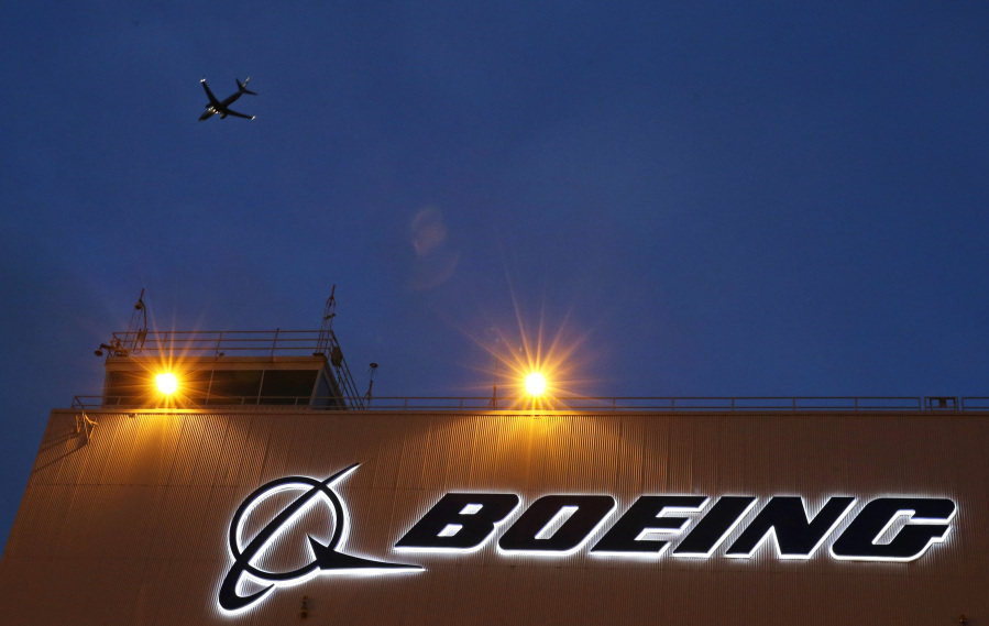 FILE - An airplane flies over a sign on Boeing&rsquo;s newly expanded 737 delivery center, Oct. 19, 2015, at Boeing Field in Seattle. The U.S. Justice Department plans to propose that Boeing plead guilty to fraud in connection with two deadly plane crashes involving its 737 Max jetliners, according to two people who heard federal prosecutors detail the offer Sunday, June 30, 2024. (AP Photo/Ted S.