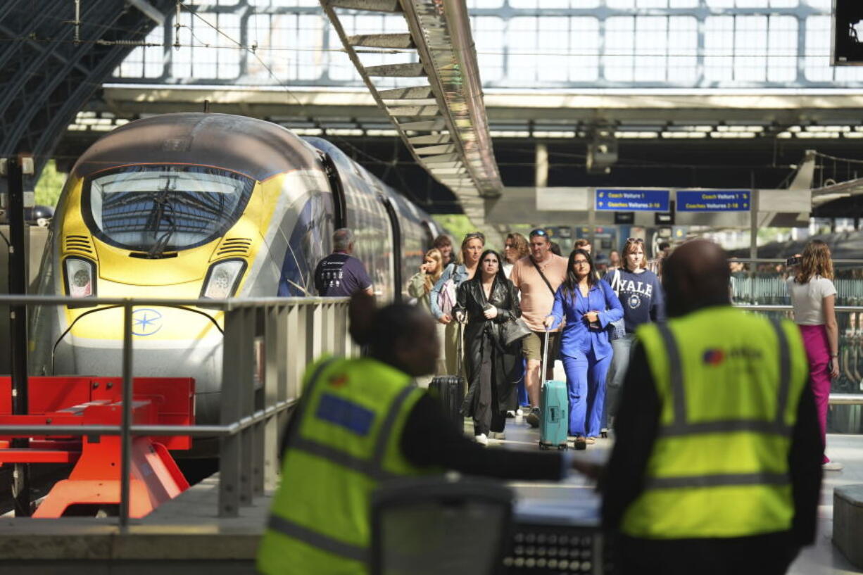 Passengers arrive by train at the Eurostar terminal at St. Pancras station in central London, Friday July 26, 2024. Hours away from the grand opening ceremony of the Olympics, high-speed rail traffic to the French capital was severely disrupted on Friday by what officials described as &ldquo;criminal actions&rdquo; and sabotage.