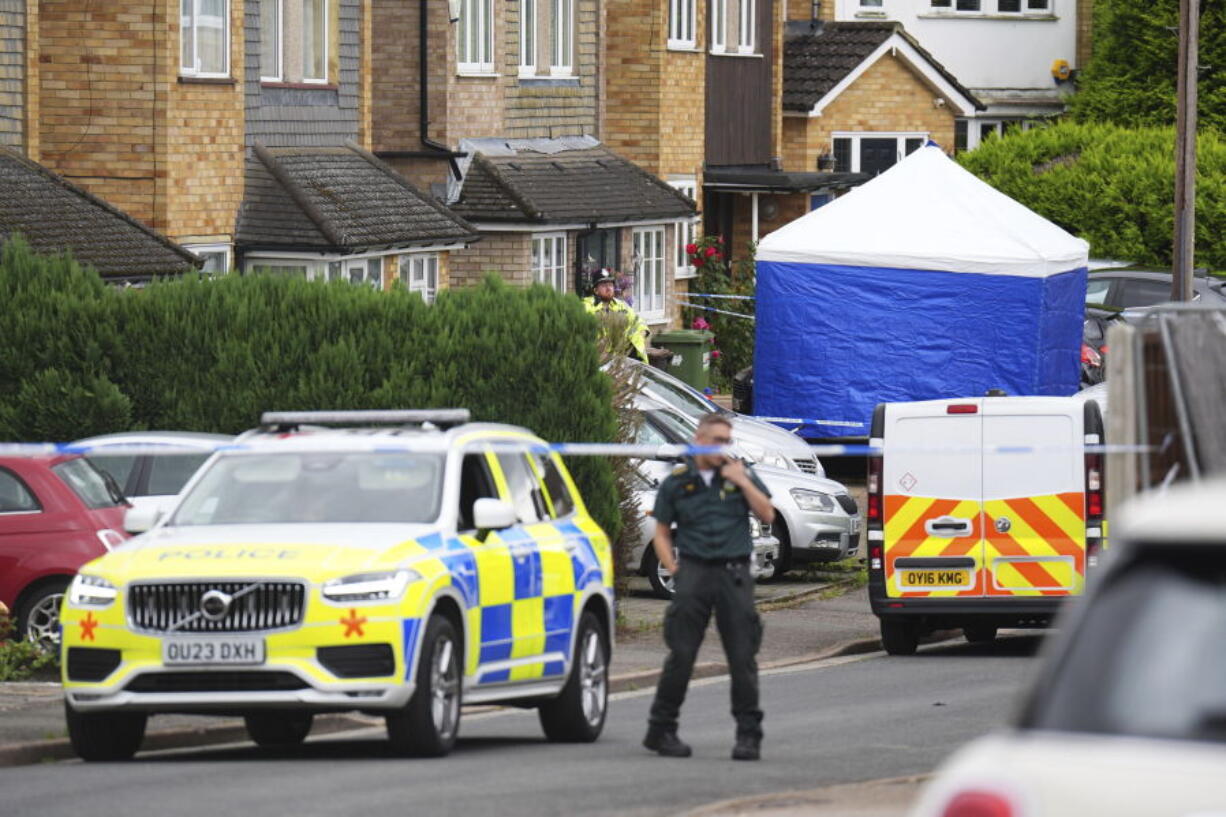 Police and emergency services at the scene in Ashlyn Close, after an incident on Tuesday evening, in Bushey, Hertfordshire, England, Wednesday, July 10, 2024. British police were hunting for a man believed to be armed with a crossbow on Wednesday after three women were killed in a house near London. The BBC said the women killed were the family of its main radio racing commentator John Hunt.