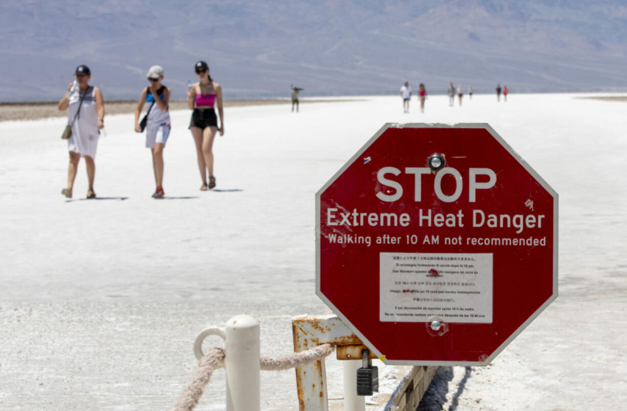 A stop sign warns tourists of extreme heat at Badwater Basin, Monday, July 8, 2024, in Death Valley National Park, Calif.