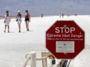 A stop sign warns tourists of extreme heat at Badwater Basin, Monday, July 8, 2024, in Death Valley National Park, Calif.