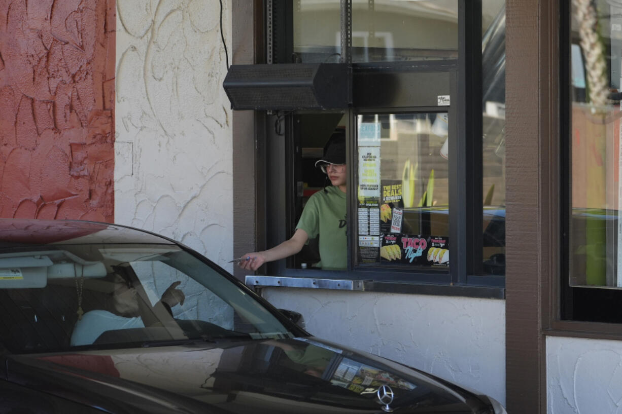 FILE - A customer pays for their food at the drive-thru of a fast-food restaurant in Los Angeles, April 1, 2024. California&rsquo;s workplace regulators passed rules that would protect indoor workers from extreme heat.
