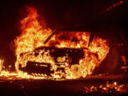 Flames consume a vehicle as the Park Fire jburns in Tehama County, Calif., on Friday, July 26, 2024.