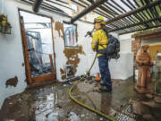 A firefighter hoses down hot spots at Noel Piri&rsquo;s home that was destroyed by the Hawarden Fire in Riverside, Calif., on Sunday, July 21, 2024.