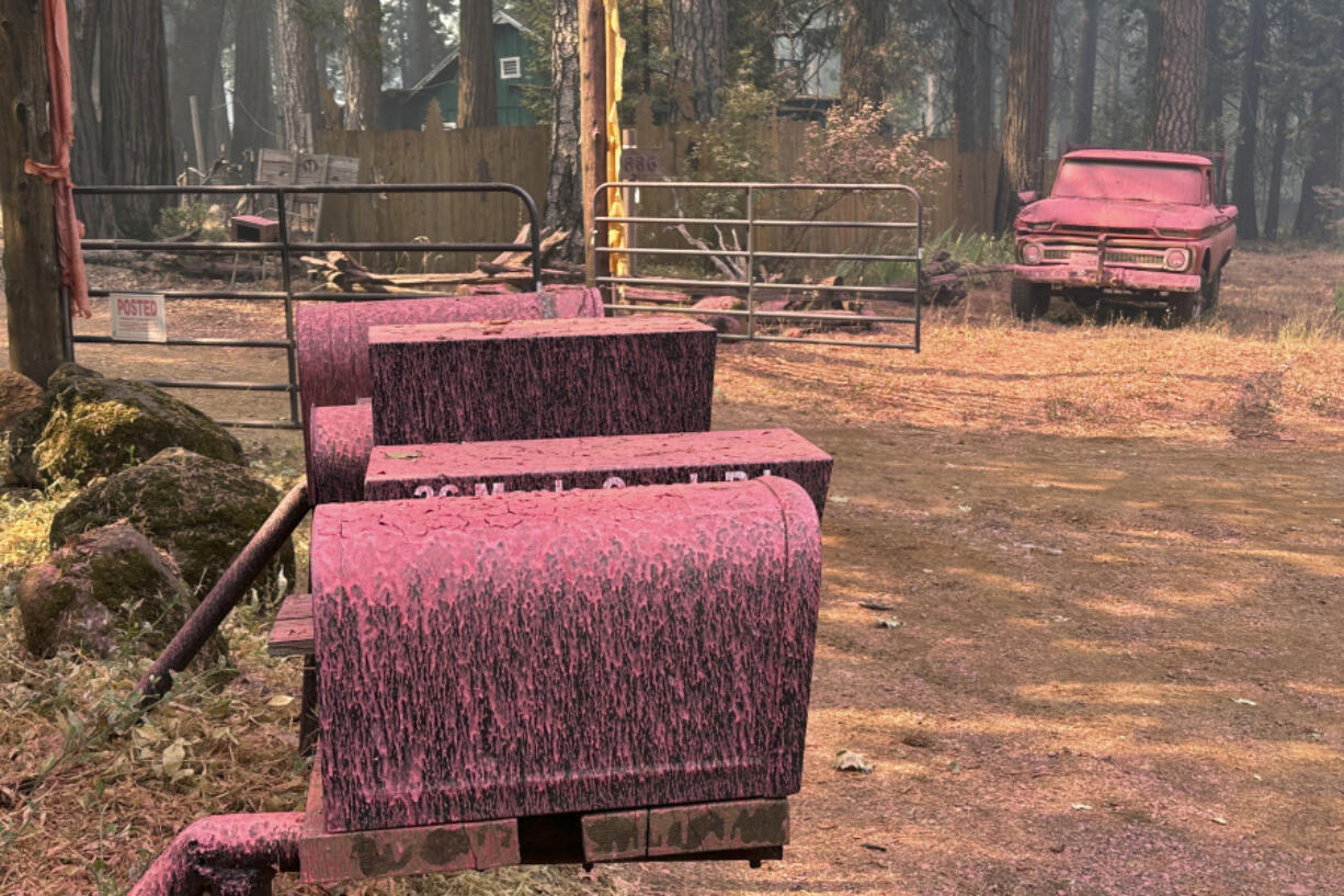 A vehicle and mailboxes are doused with retardant in the aftermath of the Park Fire, Sunday, July 28, 2024, in the Cohasset community of Butte County, Calif.