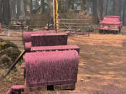 A vehicle and mailboxes are doused with retardant in the aftermath of the Park Fire, Sunday, July 28, 2024, in the Cohasset community of Butte County, Calif.