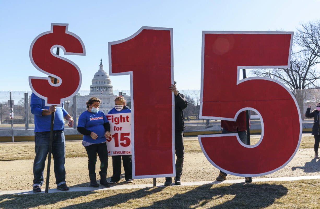 FILE - Activists appeal for a $15 minimum wage near the Capitol in Washington, Feb. 25, 2021. (AP Photo/J.