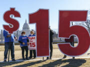 FILE - Activists appeal for a $15 minimum wage near the Capitol in Washington, Feb. 25, 2021. (AP Photo/J.